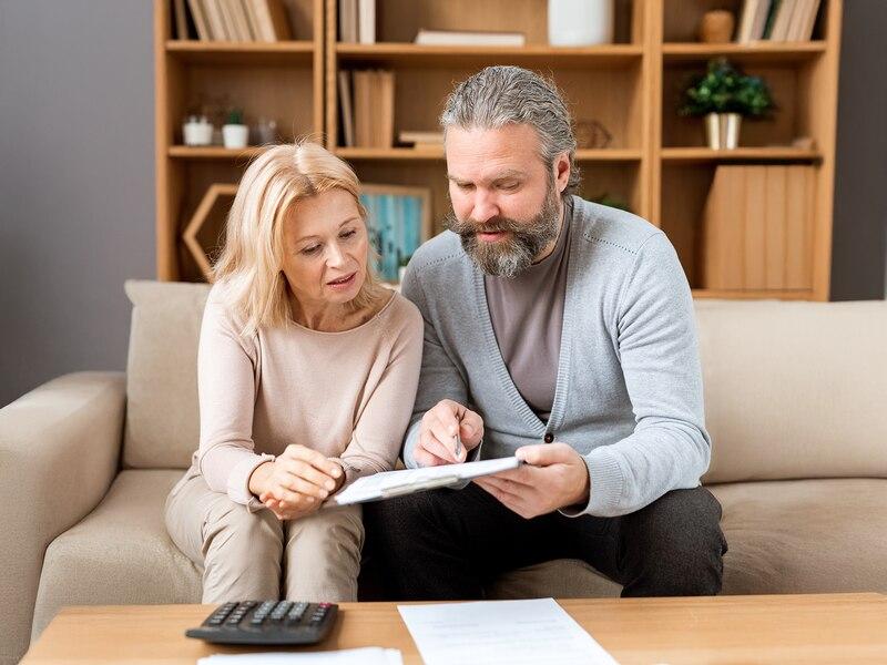 Couple d'héritiers consultant les documents de succession pour la vente d'un bien immobilier à Paris